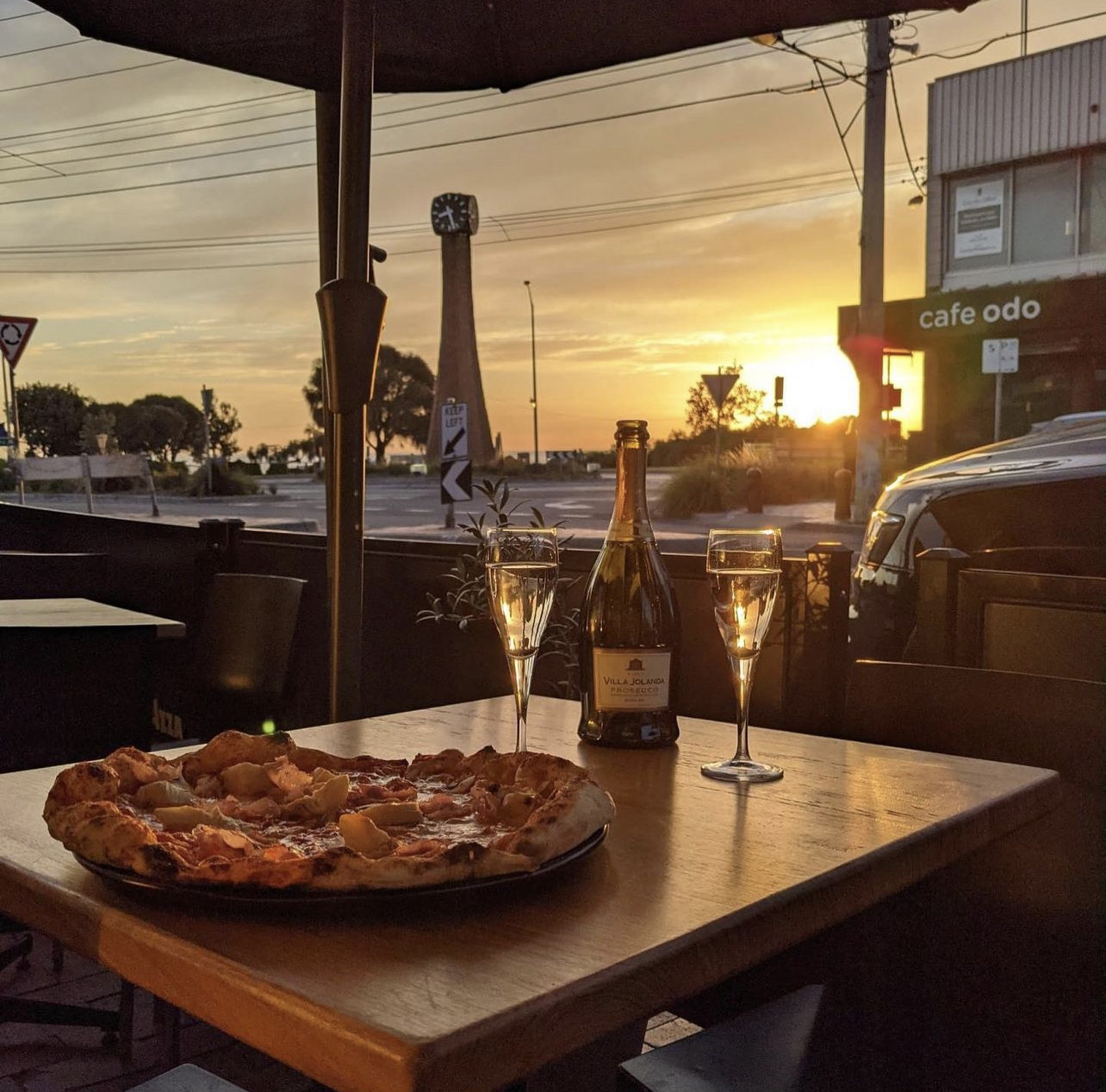 Pizza and prosecco at sunset, opposite the clock tower